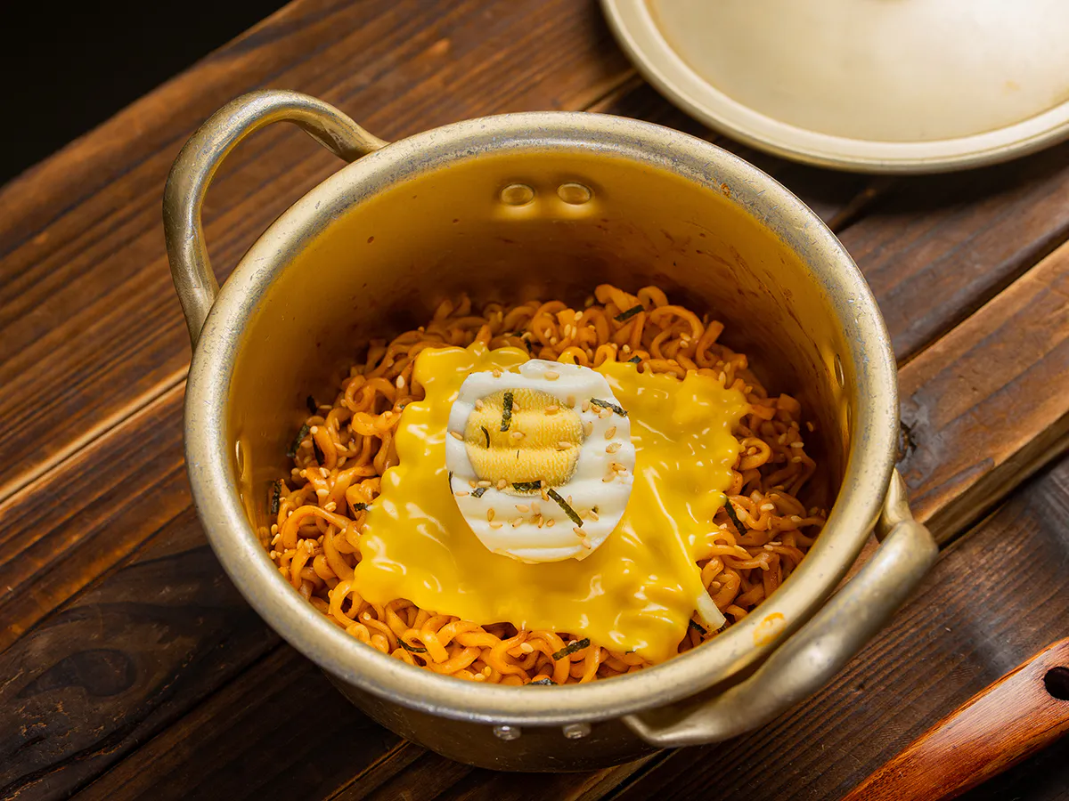 Golden pot spicy fire noodles covered cheese slice half boiled egg sesame seaweed at JBO Kitchen, an Asian Fusion Restaurant in Pomona