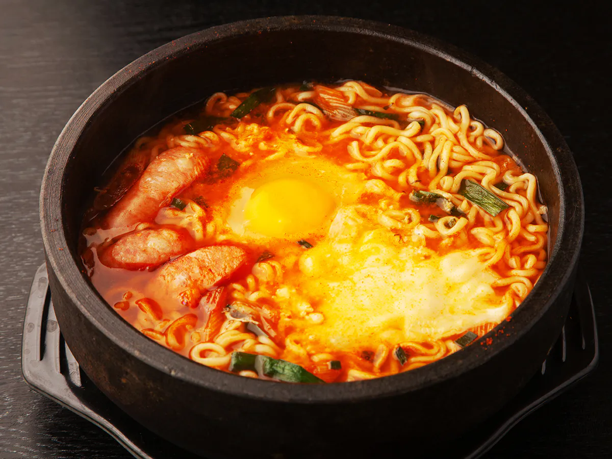 Stone pot spicy ramen with sausage runny egg melted cheese green onion at JBO Kitchen, an Asian Fusion Restaurant in Pomona