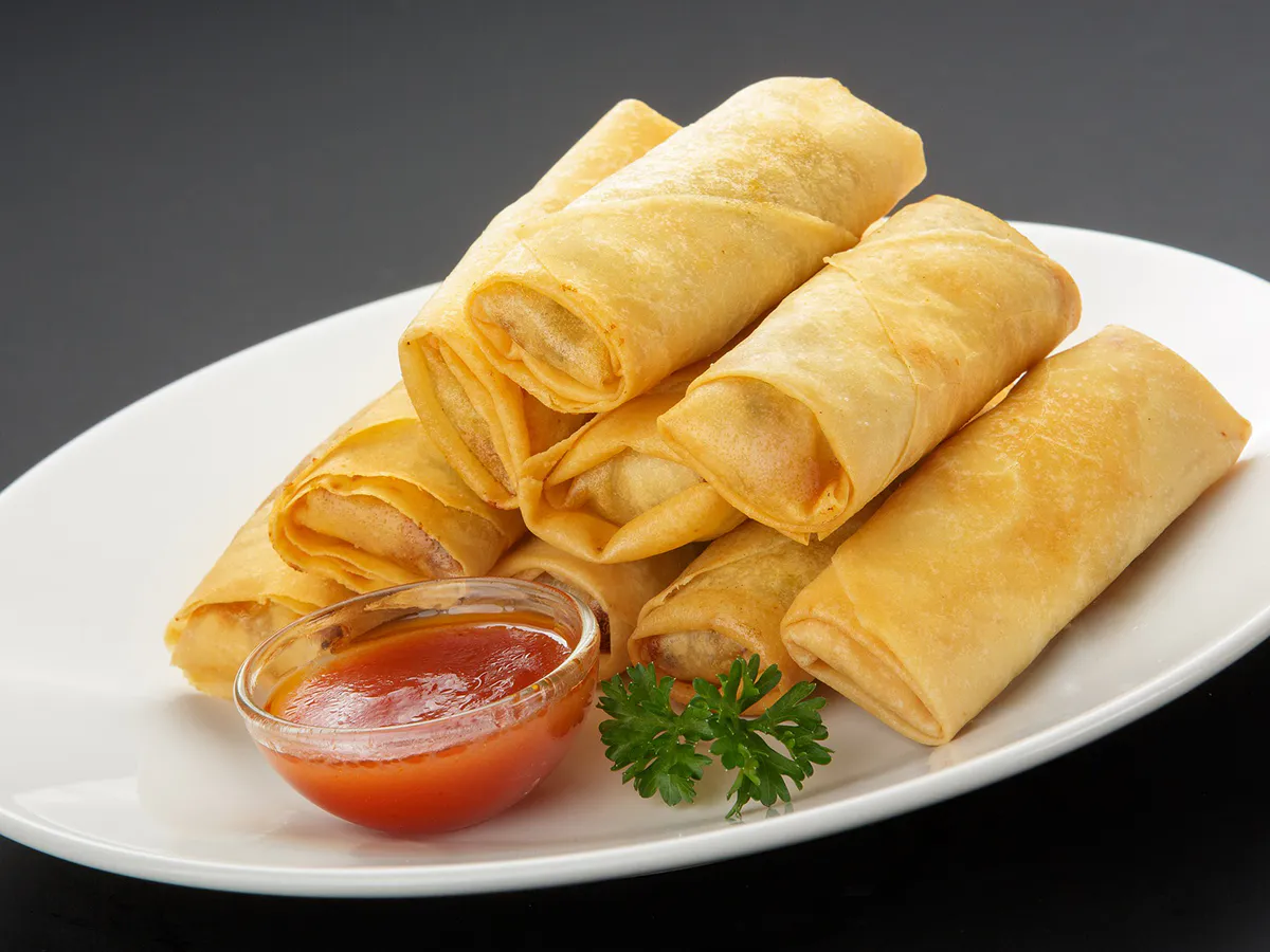 Crispy fried spring rolls with sweet chili dipping sauce parsley garnish at JBO Kitchen, an Asian Fusion Restaurant in Pomona